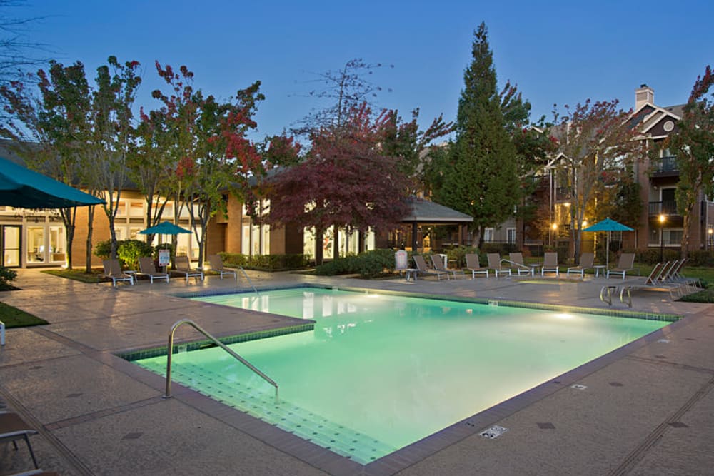 Large swimming pool at dusk with a sundeck at Cortland Village Apartment Homes in Hillsboro, Oregon