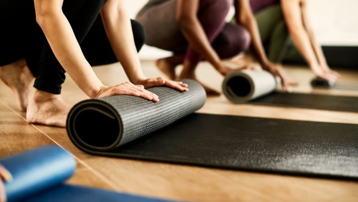 People roll up their yoga mats at a yoga studio in Midland.