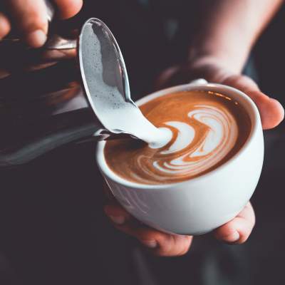 Hand with a coffee cup at a caffe near Woodmere Apartments of Venice in Venice, Florida