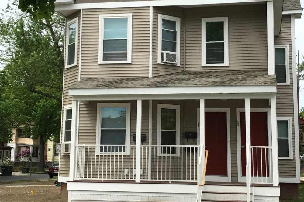 Red front door with porch at apartment building at E. Henry Twiggs Estates Phase I in Springfield, Massachusetts