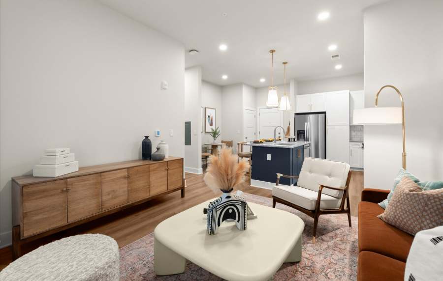 A modern living room seamlessly connected to a stylish kitchen at EVOQ East Cobb in Marietta, Georgia