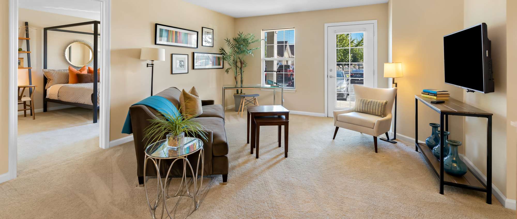 Living Room with Brown Sofa, Glass-topped Coffee Table and a Mounted Flat Screen TV at Arbor Brook in Murfreesboro, Tennessee