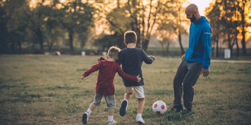 Father playing soccer with his kids in park near Chollas Heights Historical in San Diego, California