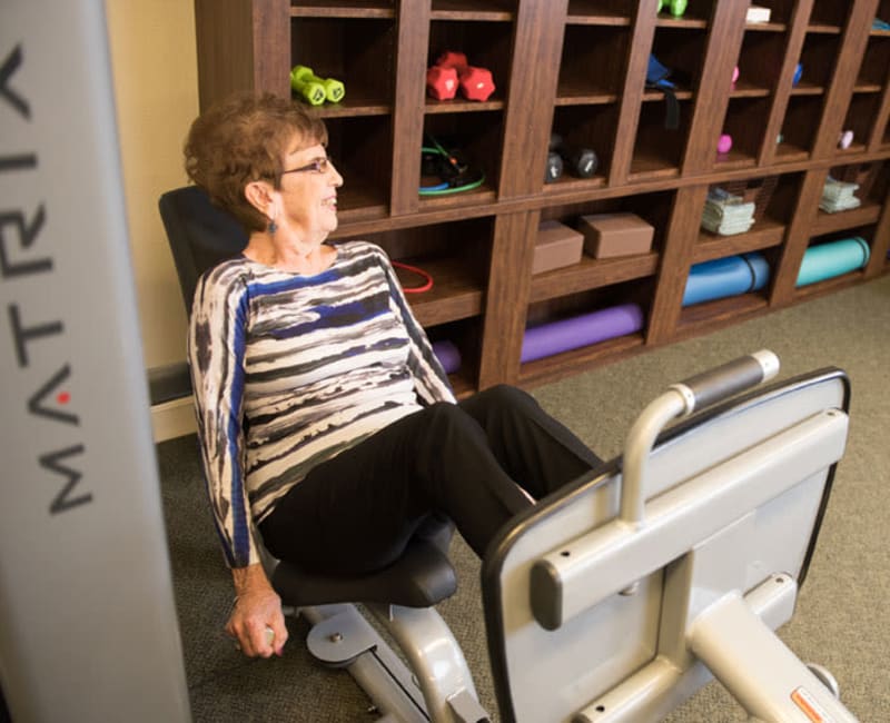 Resident working out with a leg press machine at Deephaven Woods in Deephaven, Minnesota