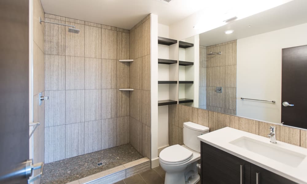 Model bathroom with a walk-in shower at 16 Powerhouse Apartments in Sacramento, California