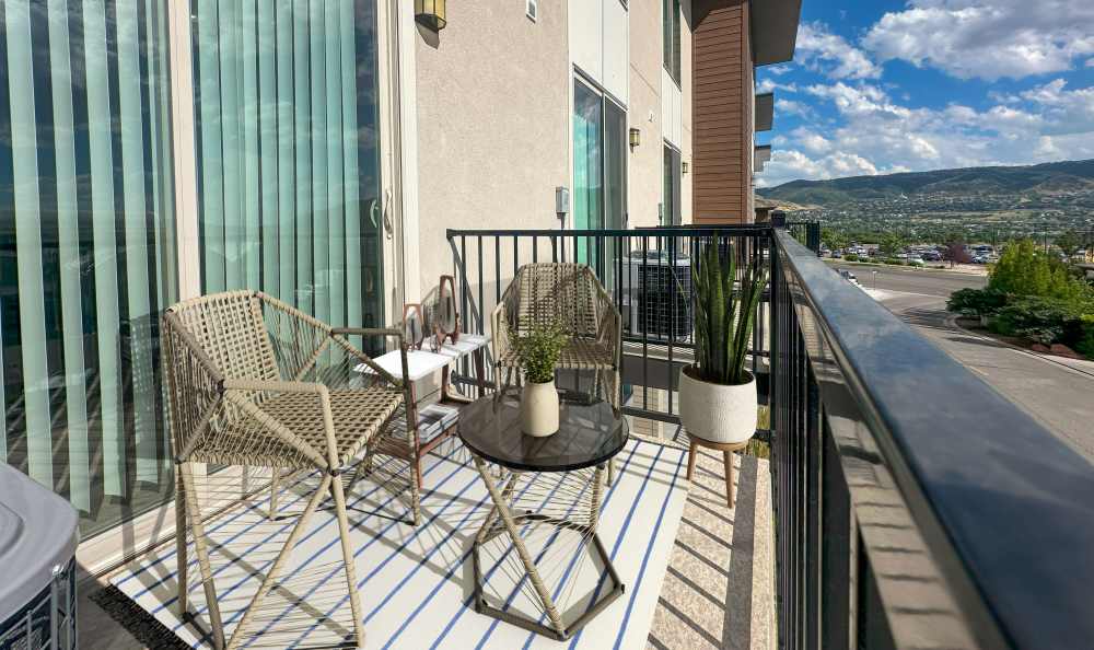 Patio with two chairs and table overlooking the valley at Liberty Point Townhome Apartments in Draper, Utah