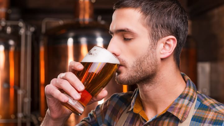 Man drinking a glass of beer.