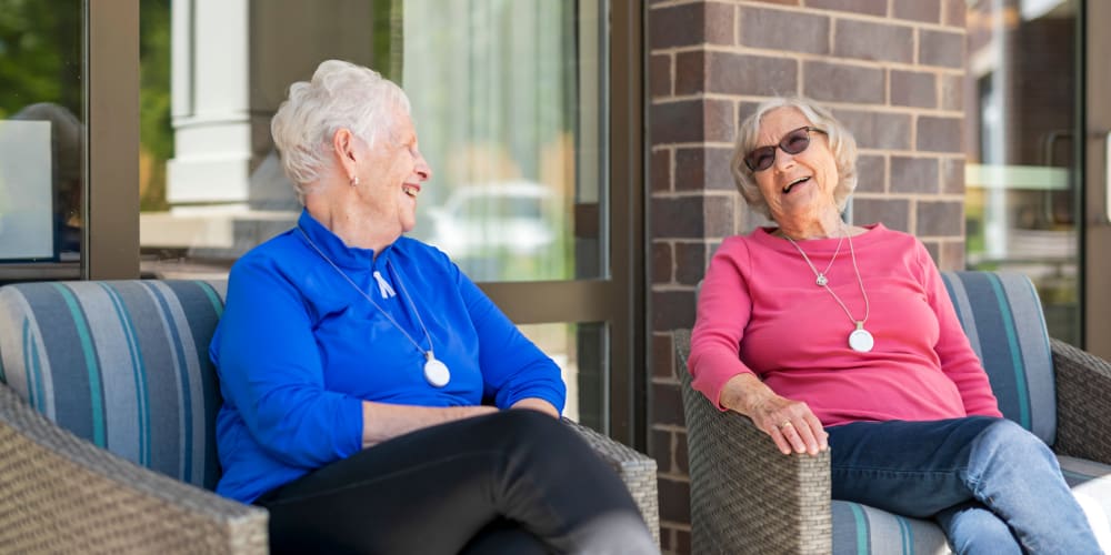 Resident and friend sitting outdoors at Anthology of Olathe in Olathe, Kansas