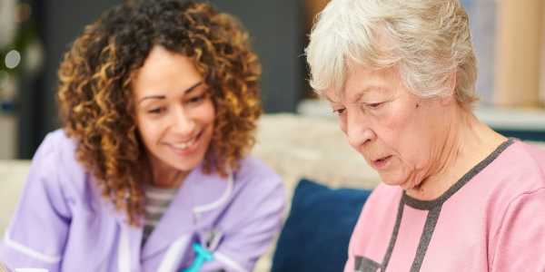 Seated resident couple holding hands at Transitions At Home in Spooner, Wisconsin