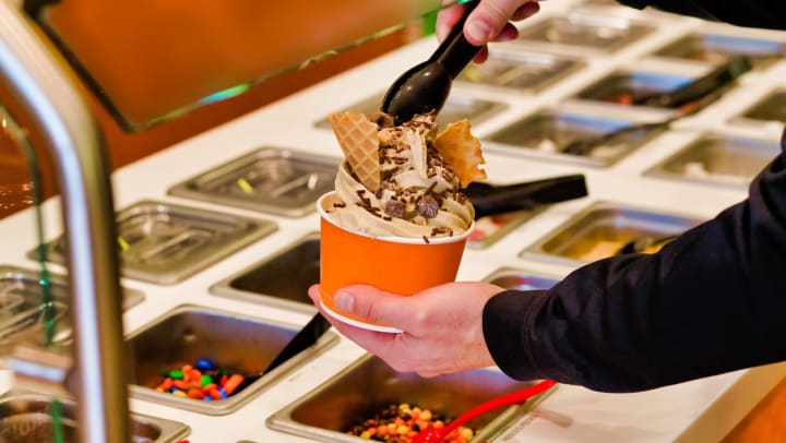 A person topping their frozen yogurt bowl in Tampa