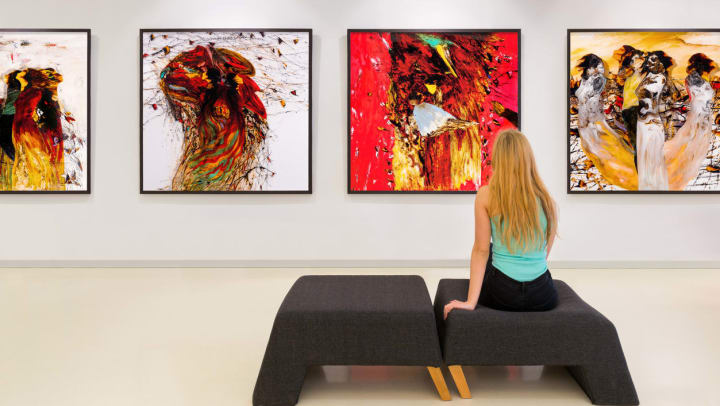 Woman viewing artwork on the wall at an art gallery.