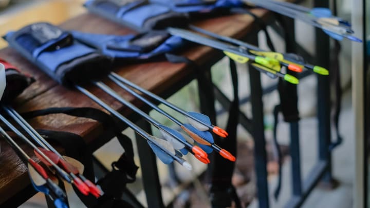 A close-up shot of a multi-colored arrows inside their quivers lying on a table at an archery range in Gilbert.