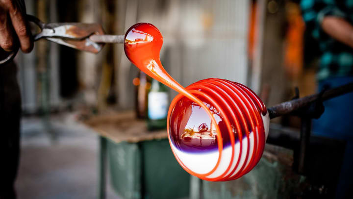 Person creating handmade glassblowing art at a studio