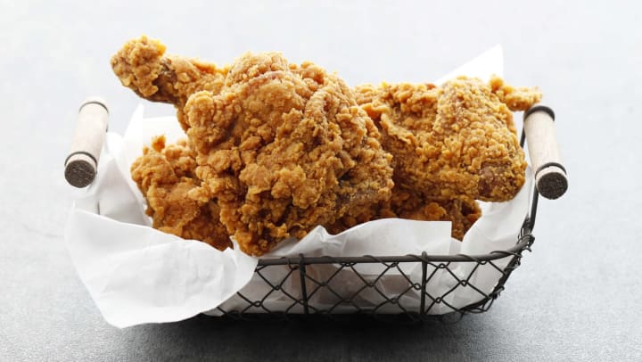 Homemade crispy fried chicken in a wire basket on a white background | Chicken in Albuquerque