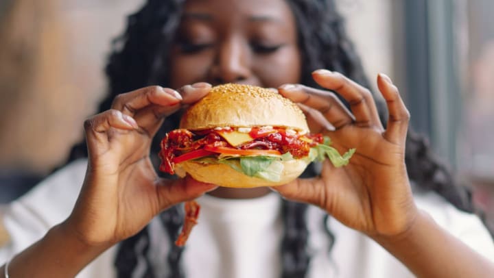 woman eating a burger in a restaurant | Nashville Restaurants