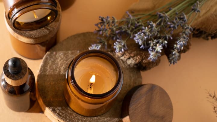 Soy candle in an amber glass jar burning next to a bundle of lavender. | candle shops in Chandler
