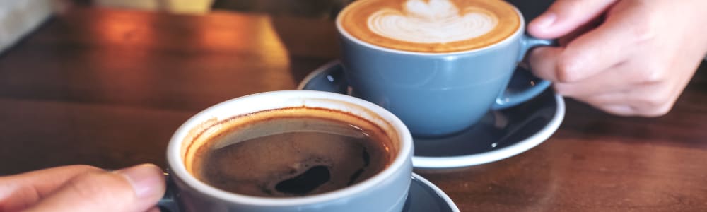 Two cups of coffee on a table in a shop near Walnut Creek Apartments in Macon, Georgia