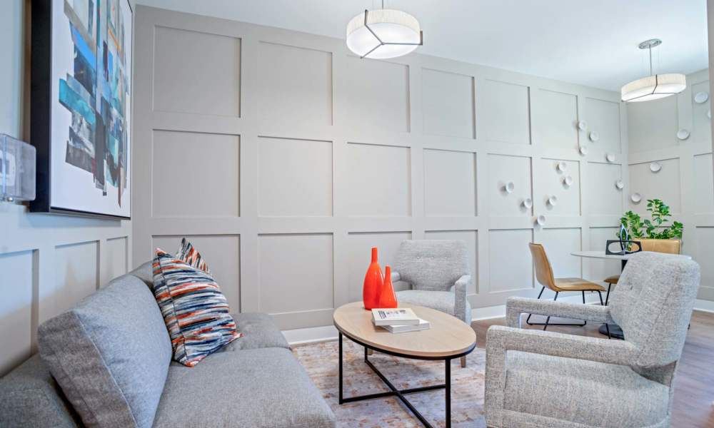 Cozy lounge area with modern furniture, decorative wall art, and natural light from windows at Crestwood Manor in Frederick, Maryland