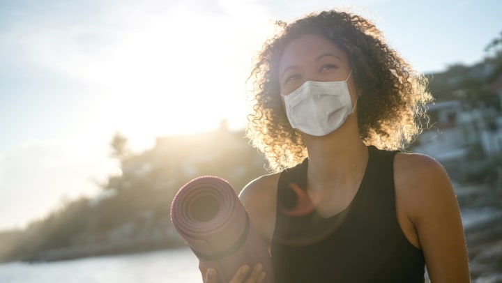 Woman holding a yoga mat at Olympus Gran Crossing in Katy, Texas