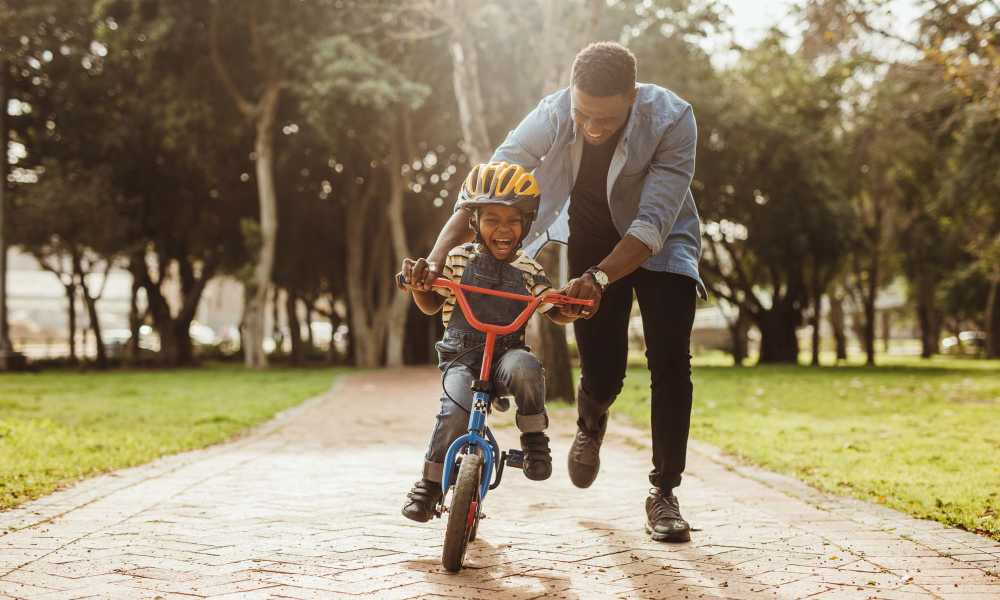 Residents child learning to ride bicycle in park near Burnett Place Apartments in Taylor, Texas