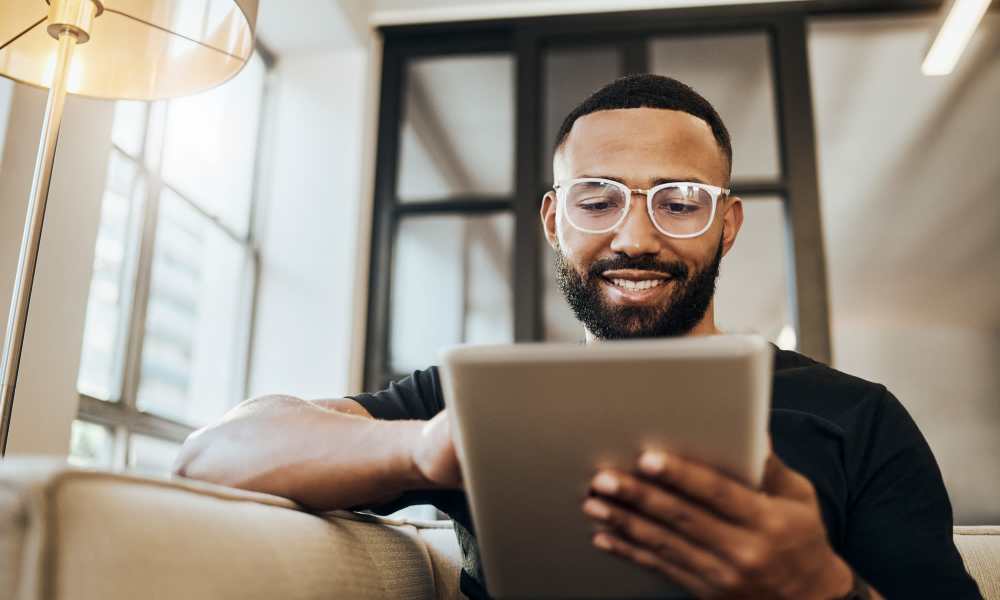 Resident facilitating high-speed internet amenity on his tablet at MeadowView Townhomes in Goshen, Ohio