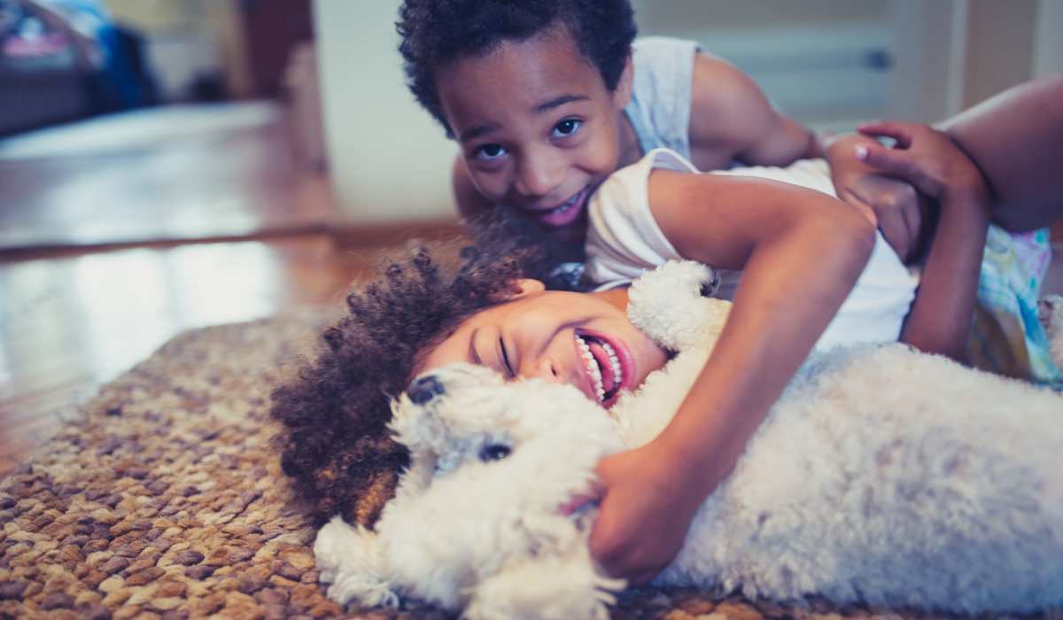 Children playing with their pup in their home at The Standard at Pinestone in Travelers Rest, South Carolina