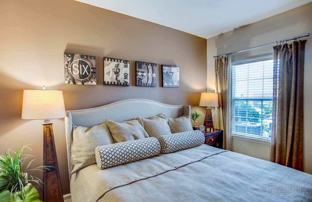 Bedroom with large comfortable bed at Highland Hills Apartments in Dothan, Alabama