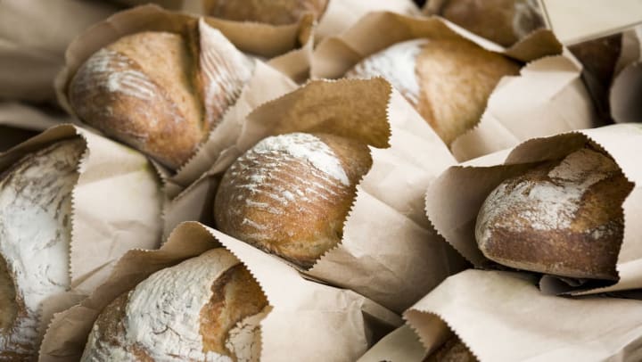 A close-up of fresh baguettes wrapped in paper | Durango bakeries