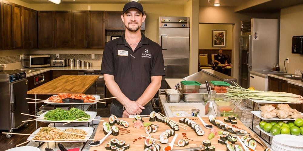 Chef in front of sushi buffet for residents of The Springs at Veranda Park in Medford, Oregon