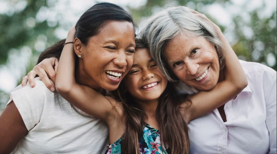 Three generations of a family posing for a photo at Cascade Park Vista Assisted Living in Tacoma, Washington