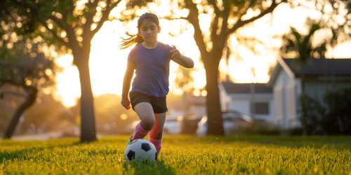 Girl playing soccer in a park near Mountain Breeze Villas in San Bernardino, California