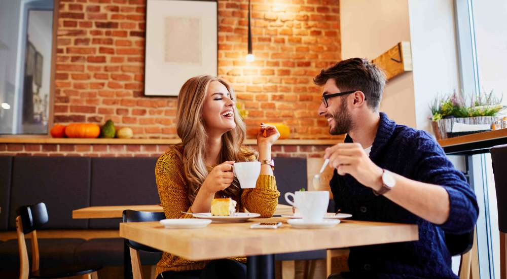 Residents engaged in conversation while sitting together at a cafe table near Fairways Villas II Apartments in Victor, New York