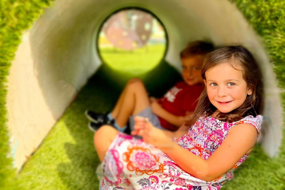 Happy kids playing in tunnel at BB Living Harvest in Argyle, Texas