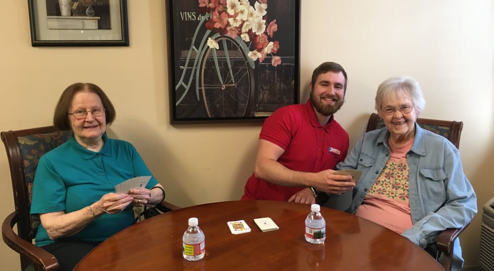 Memory care residents playing a game of cards at Patriots Glen in Bellevue, Washington. 