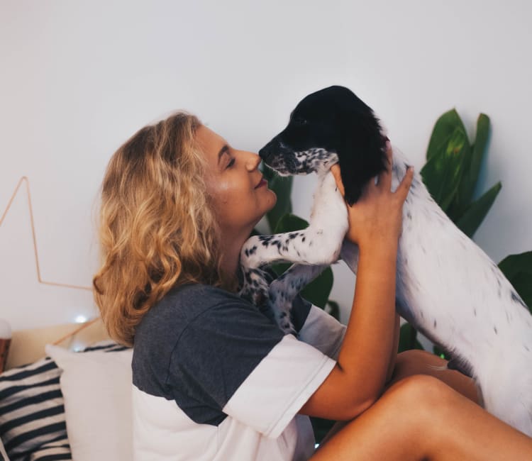 Resident giving her puppy a kiss in her new home at Haven Warner Center in Canoga Park, California
