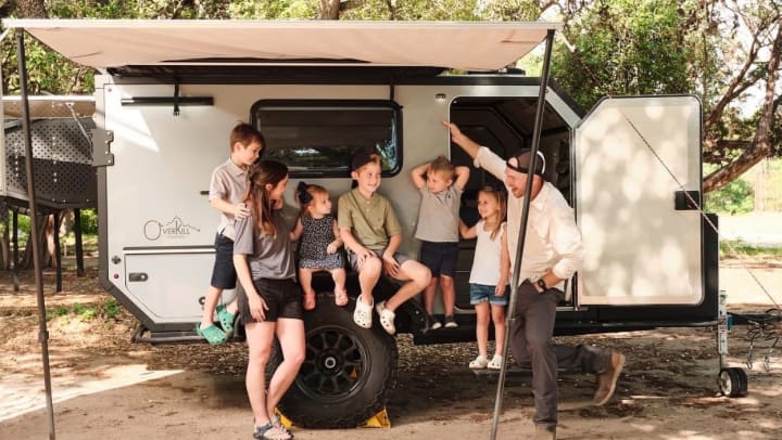 Adventure ATX Rentals family laughing together in front of camper