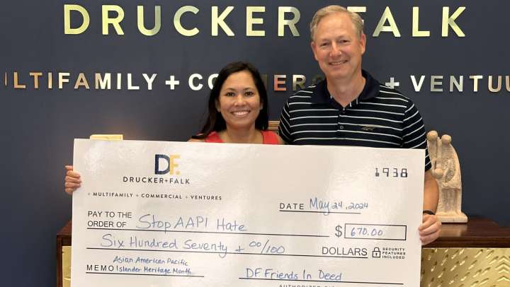 Couple posing with the check for their philanthropic work
