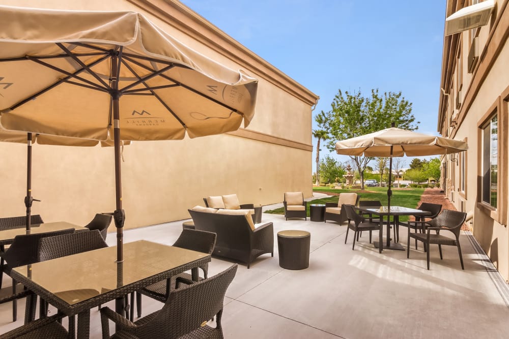 outdoor courtyard with umbrellas and seating at Truewood by Merrill, Henderson in Henderson, Nevada
