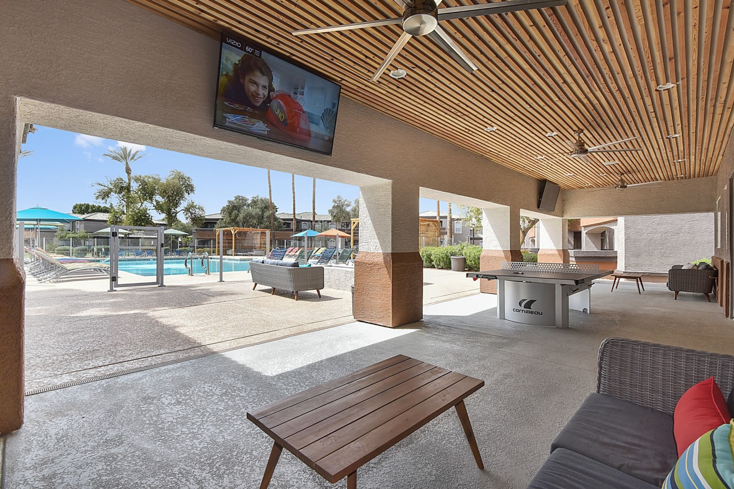 Covered patio seating with ping pong and a TV at Luxe @ Ocotillo in Chandler, Arizona