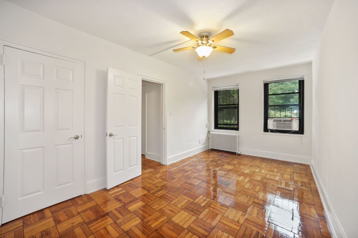 Well lit bedroom with a nice ceiling fan to help you stay cool at Rock Creek Gardens in Washington, District of Columbia