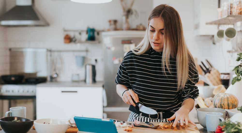 Resident chopping vegetables in the kitchen at Monarch West in Houston, Texas