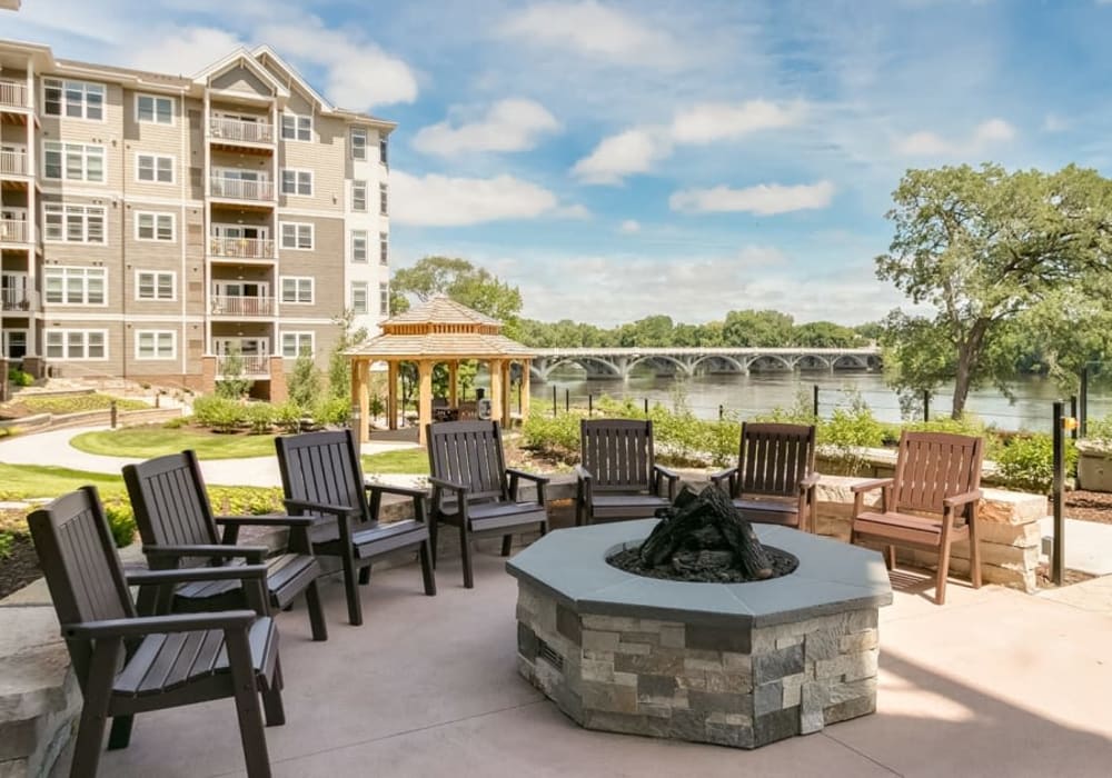 Row of deck chairs situated around a fire pit outside of an Applewood Community