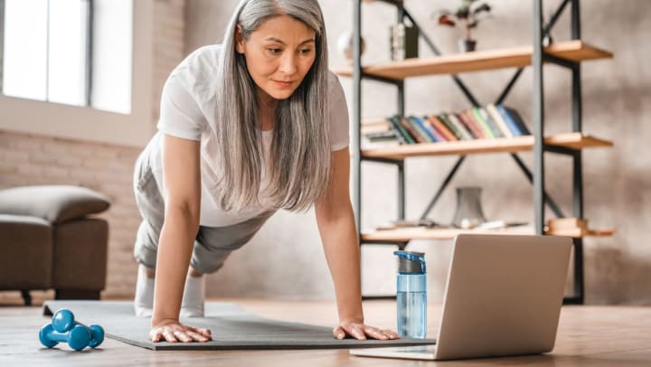 Person doing a plank in front of the computer in a living room