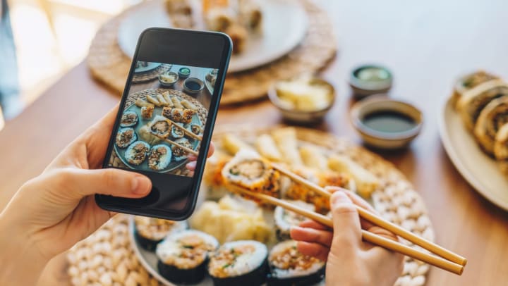 hand taking a photo of sushi at home | photo tips for social media at home