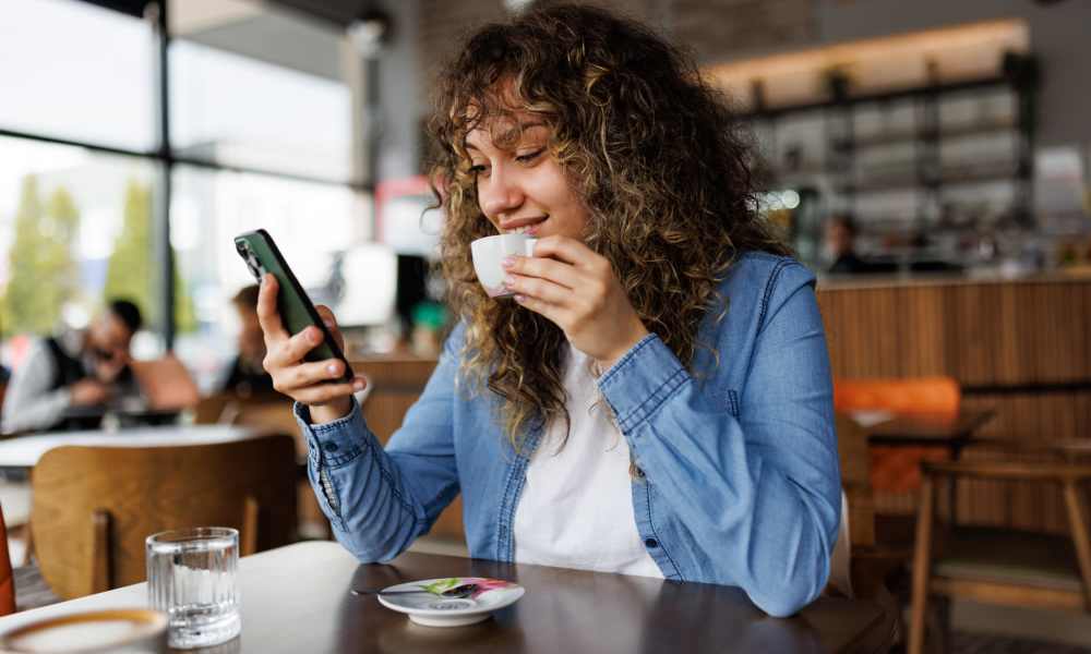 Residents with her phone in cafe near Brookland Artspace Lofts in Washington, District of Columbia