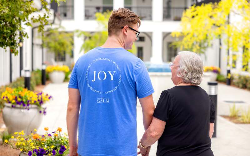 Resident walking with a team member at Glenncrest at Webb Gin in Lawrenceville, Georgia