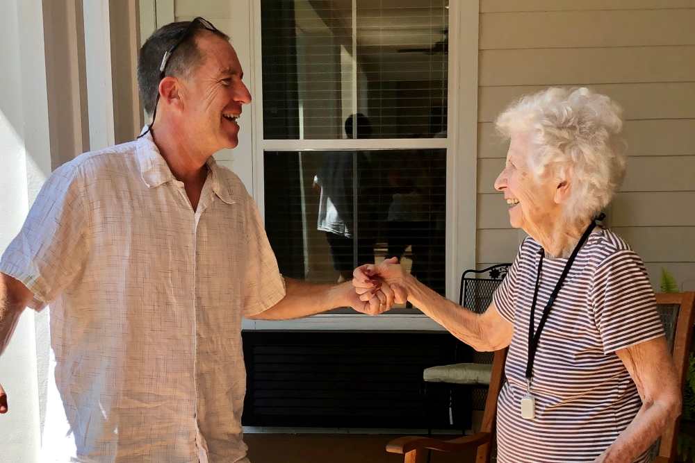 Staff member dancing with a resident on the patio at Ashley Park in Charleston, South Carolina