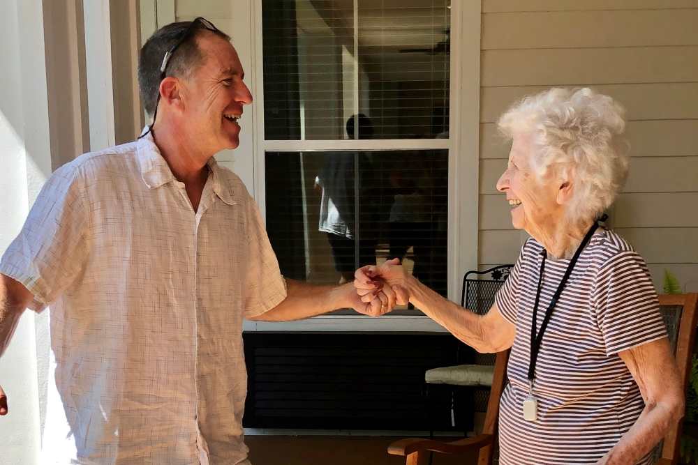 Staff member dancing with a resident on the patio at Glenncrest at Siegen in Baton Rouge, Louisiana