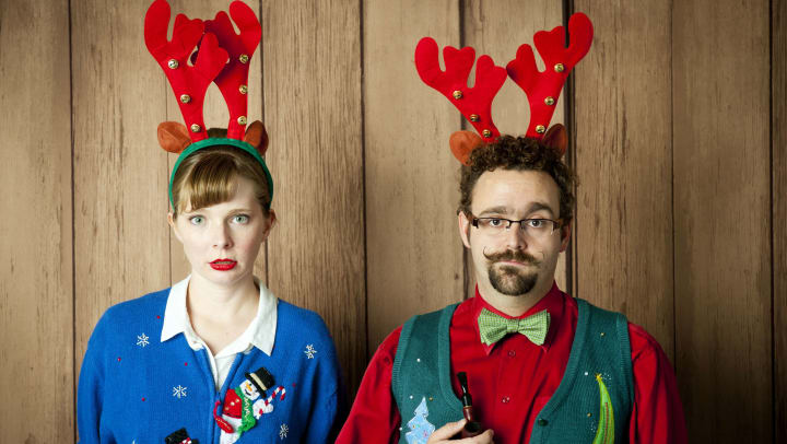 Couple wearing ugly Christmas sweaters 