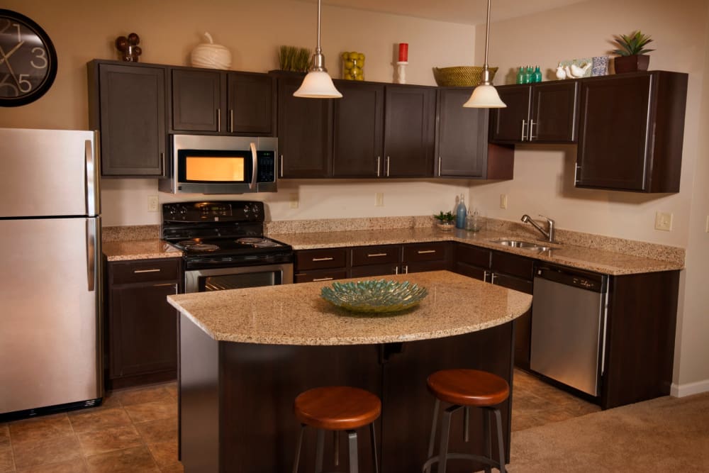 Modern kitchen with a large island and pendant lighting at Rochester Village Apartments at Park Place in Cranberry Township, Pennsylvania
